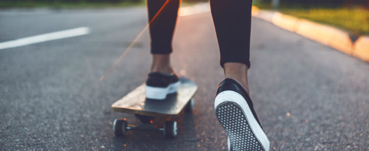 Close up of woman's legs skateboarding on a street