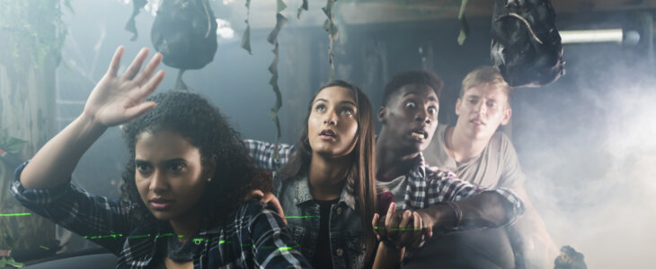 Teenagers walking through a haunted house looking scared